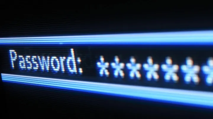 Close-up of a glowing blue screen showing a password prompt filled with asterisks